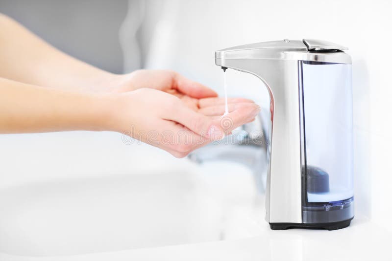 Hands and automatic soap dispenser royalty free stock photo