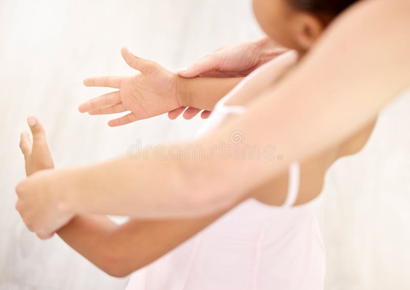 Hands, ballet and dance with a teacher and student in a class for dancing or performance arts. Artistic, dancer and learning with a girl ballerina in a classroom with an instructor from above.