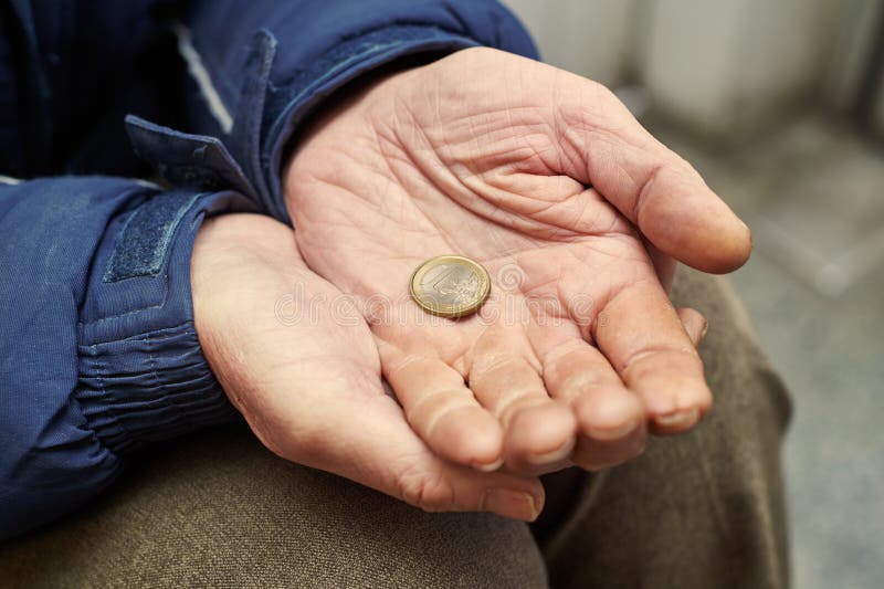Hands of beggar with one euro coin begging for money. Beggar people and human poverty. Male hands of homeless person with one euro charity in city street stock photo Hands of beggar with one euro coin begging for money. Beggar people and human poverty. Male hands of homeless person with one euro charity in city street stock photo