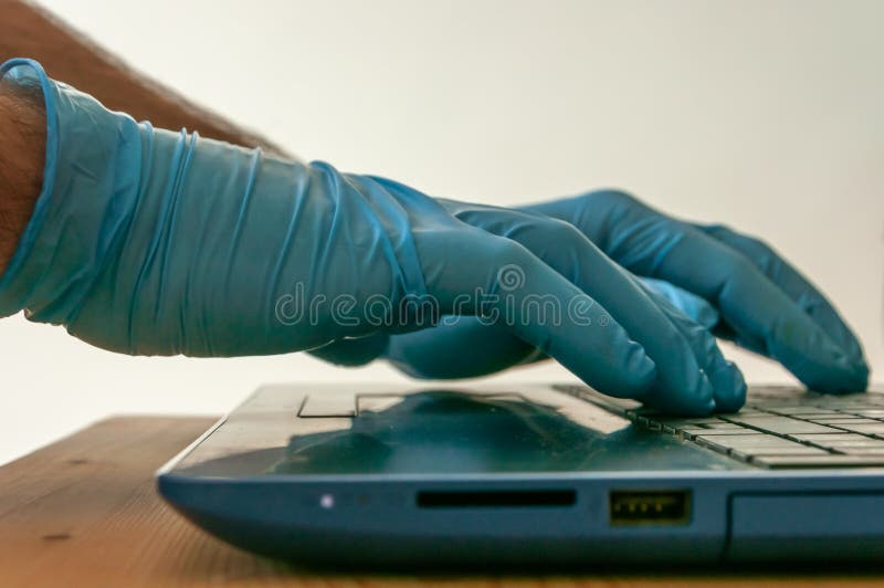 Hands with Blue Nitrile Gloves Using a Labtop Keyboard Stock Image