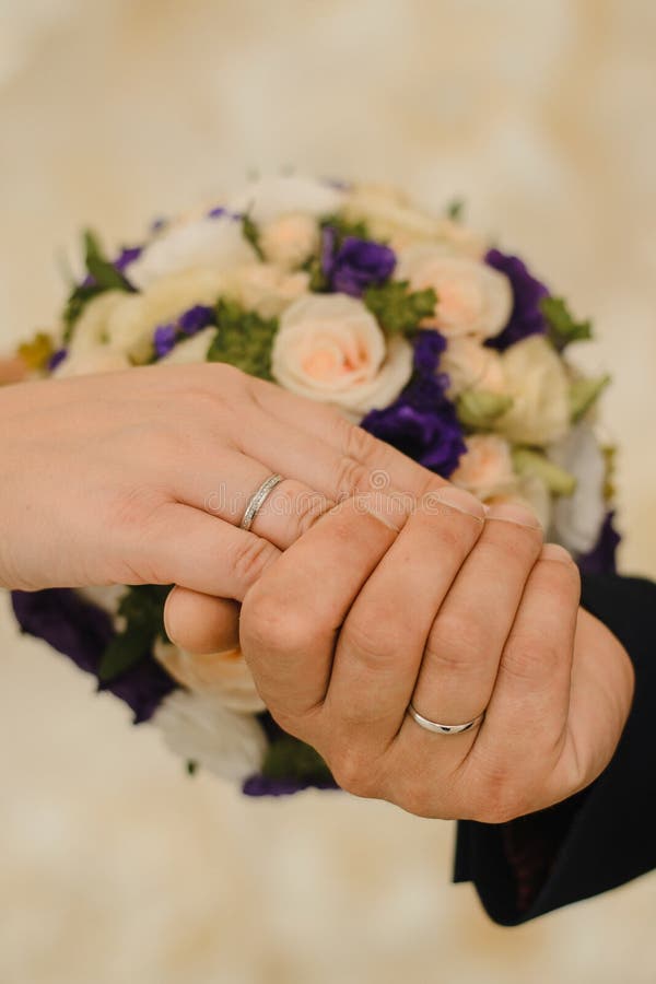 Hands of the bride and groom with wedding rings on the background of a delicate bouquet. stock image Hands of the bride and groom with wedding rings on the background of a delicate bouquet. stock image