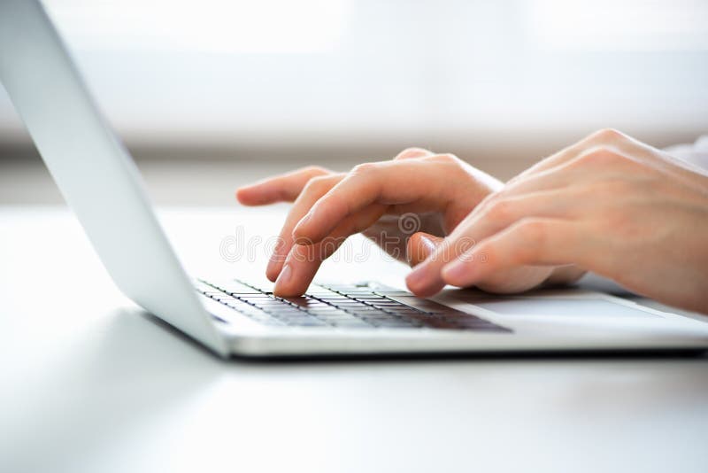 Hands of business man typing on a laptop.