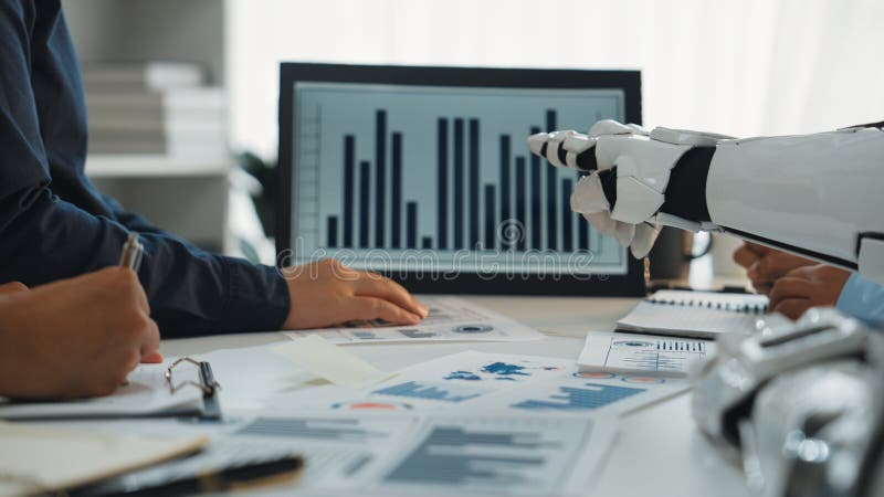 Hands of Business Team Discussing Data Analysis with Robotic Arm Presenting Graphs on Digital Screen in Modern Office stock photography