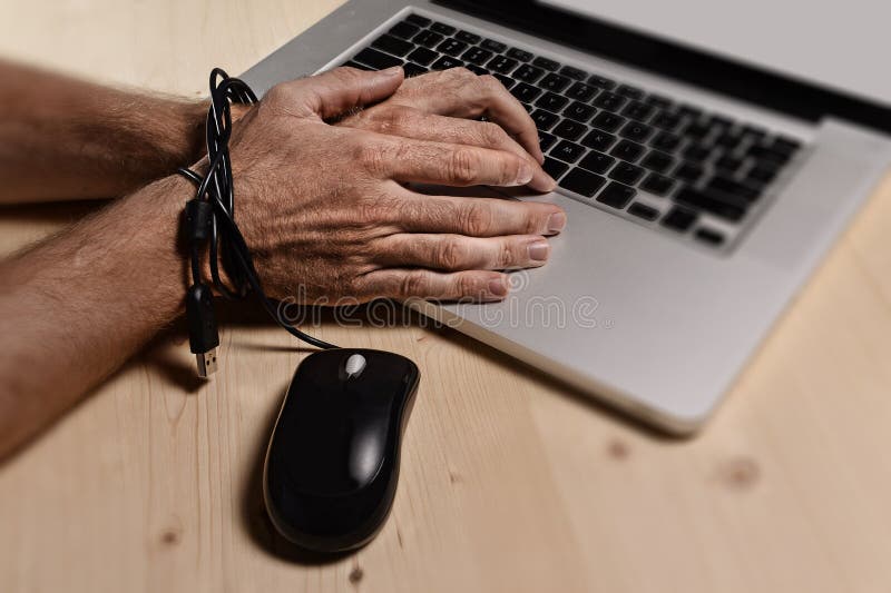 Hands of businessman addicted to work bond with mouse cable to computer laptop in workaholic stock photography