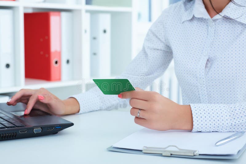 Hands of businesswoman in suit holding credit card and making online purchase using notebook pc. stock photo Hands of businesswoman in suit holding credit card and making online purchase using notebook pc. stock photo