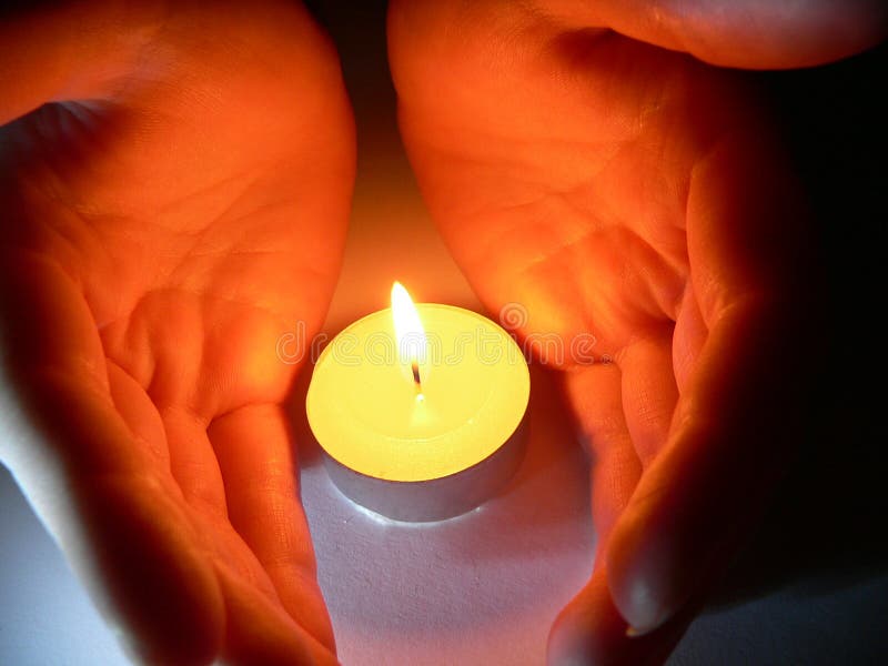 Hands and a candle stock photography