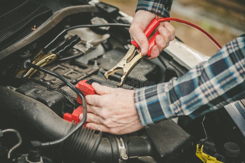 Hands of Car Mechanic Using Car Battery Jumper Cable Stock Image