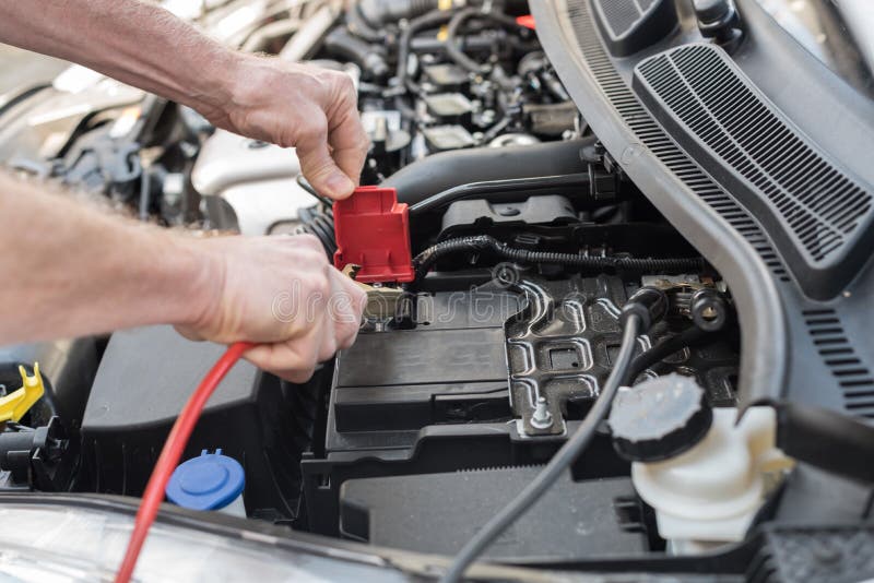 Hands of Car Mechanic Using Car Battery Jumper Cable Stock Image