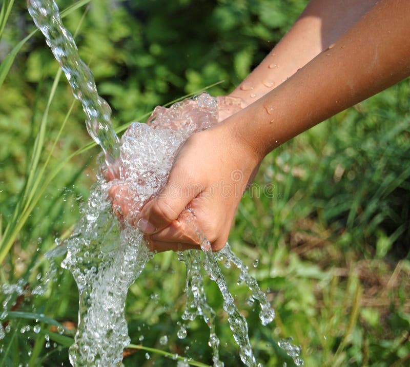 Hands catching clean falling water close up