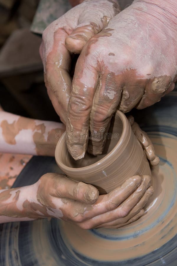 hands of the child and adult molded ceramic vesse