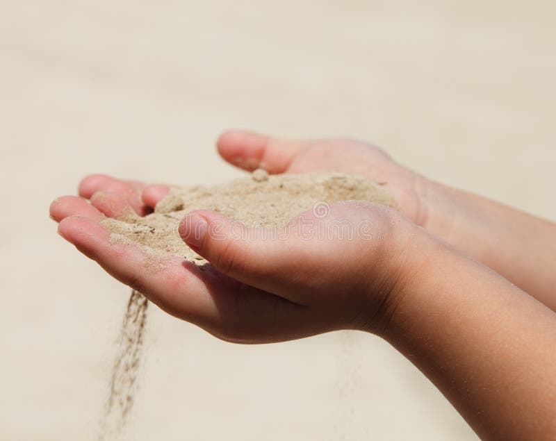 Hands of the child holding sand