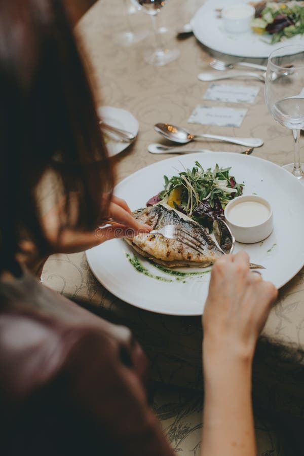 Hands Close Up with Etiquette Cutlery. Eating a Fish Dish Close Up