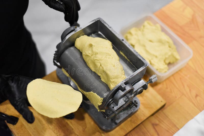 Hands Cooking Tortillas for Tacos with the Machine in a Mexican