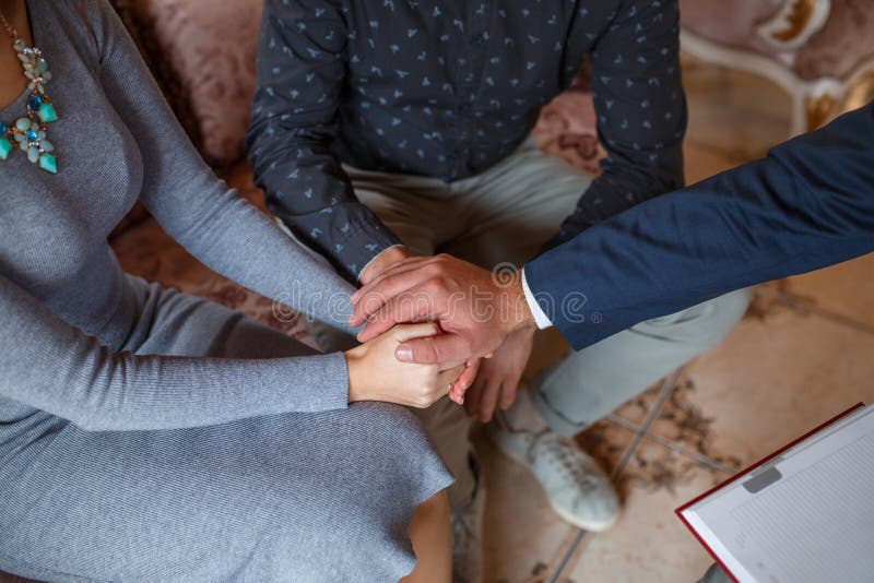 The hands of the couple together, the psychologist`s hand on top of the reception royalty free stock photo The hands of the couple together, the psychologist`s hand on top of the reception royalty free stock photo