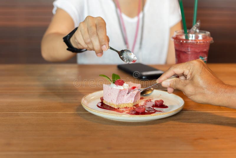Hands Eating Currant Mousse Cake with Spoon in Cafe. Stock Photo