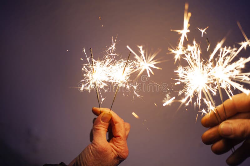 hands of elderly couple holding sparkles celebrating New Year stock photography hands of elderly couple holding sparkles celebrating New Year stock photography