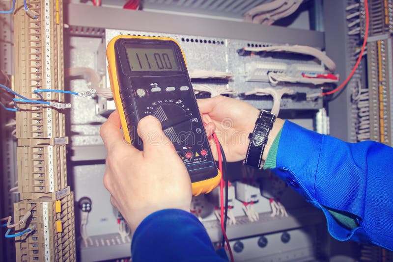 Hands of electrician close-up with multimeter. stock photography