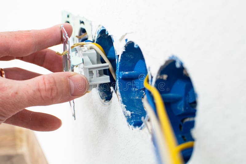 Hands of electrician installing electrical socket with new home. Home electrician stock images, royalty-free photos and pictures