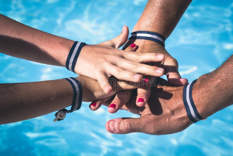 Each of the four hands is clasped around the friends wrist. One hand grips  the other, and so on. Young girls hands. Stock Photo by ©info.fotodrobik.pl  424891214