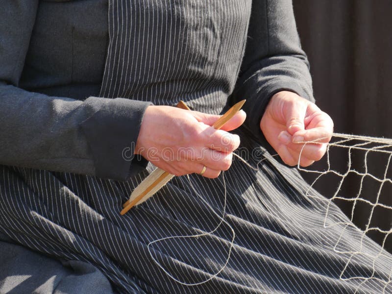 Hands of a Fisherman`s Wife Weaving a New Fishing Net for Fish