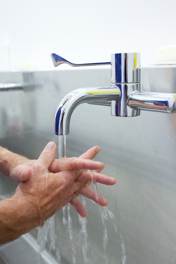 Surgeon washing hands prior to operation using correct technique for cleanliness. Surgeon washing hands prior to operation using correct technique for cleanliness