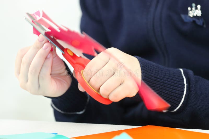 Hands of girl cutting flower from red paper for crafts royalty free stock image Hands of girl cutting flower from red paper for crafts royalty free stock image