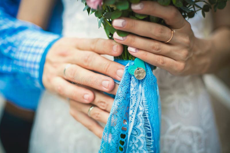 Hands of groom holding bride with wedding bouquet stock photography Hands of groom holding bride with wedding bouquet stock photography