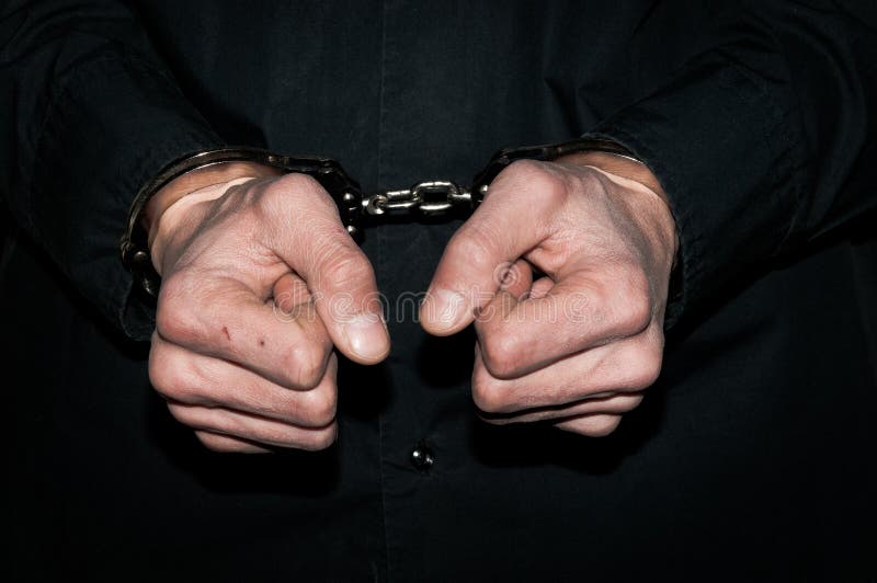 Hands of handcuffed criminal man in black shirt. royalty free stock image Hands of handcuffed criminal man in black shirt. royalty free stock image