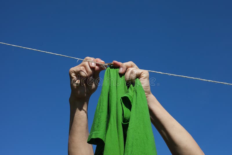 Hands hanging clothes.