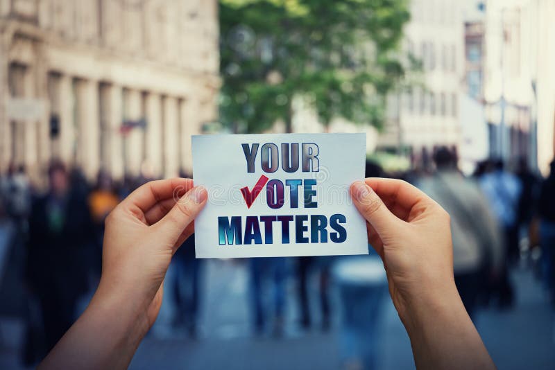 Hands hold a paper sheet with the message your vote matters over a crowded street background. People legal and democratic rights,. Every voice counts. Election royalty free stock photo Hands hold a paper sheet with the message your vote matters over a crowded street background. People legal and democratic rights,. Every voice counts. Election royalty free stock photo