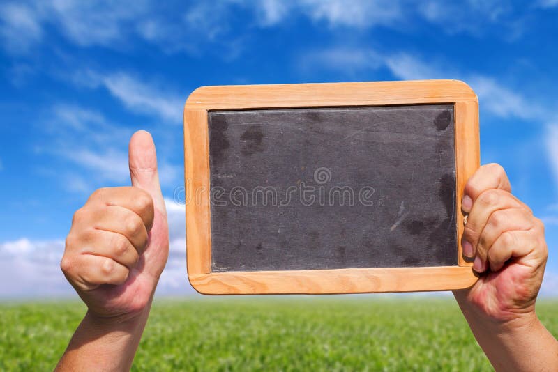 Hands holding a blank slate blackboard in the air