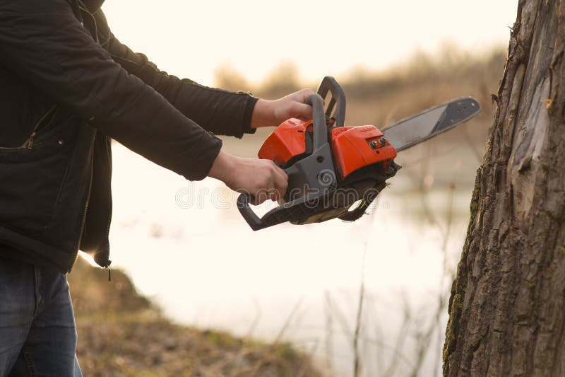 Hands holding a chainsaw stock photos Hands holding a chainsaw stock photos