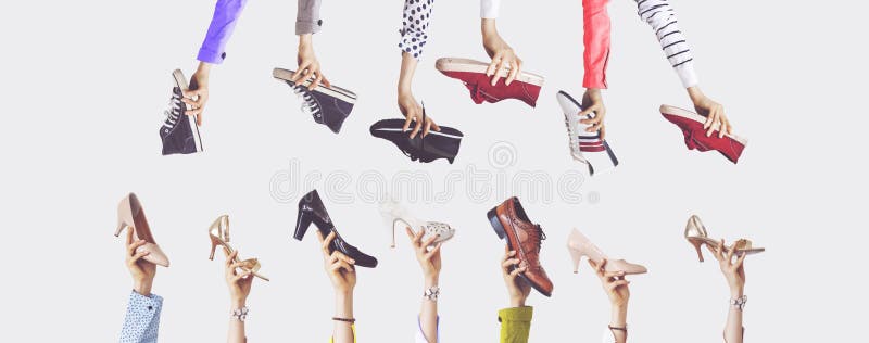 Hands holding different shoes on isolated background