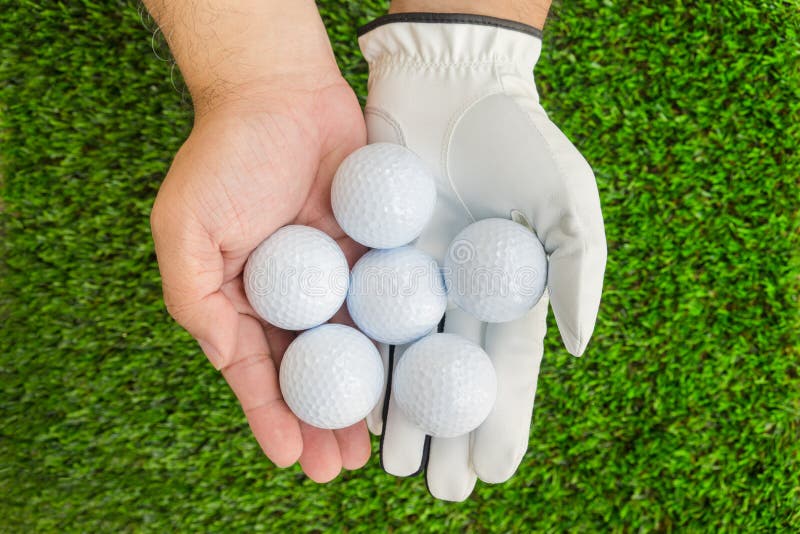 Hands holding 6 golf balls