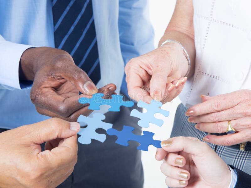 Hands Holding a Jigsaw with Business Concepts