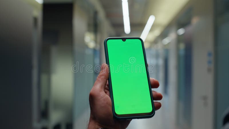 Hands holding mockup mobile phone in office vestibule closeup. Man strolling stock video footage