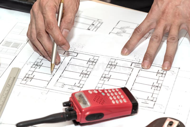 Architecture hands holding pen point to architectural plans project drawing, architect engineering and contractor concept