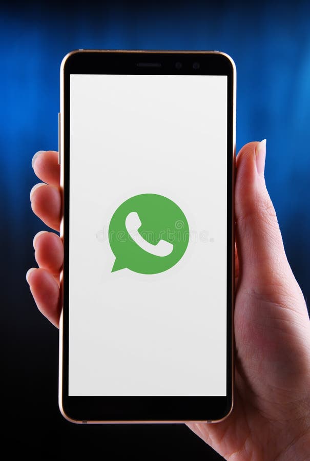 Hands Holding Smartphone Displaying Logo Of Whatsapp Messenger