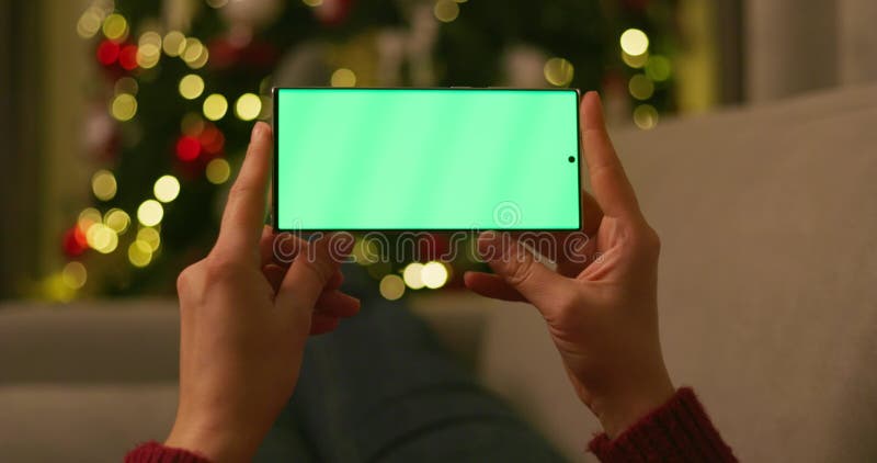 Hands holding smartphone with green screen at night stock footage