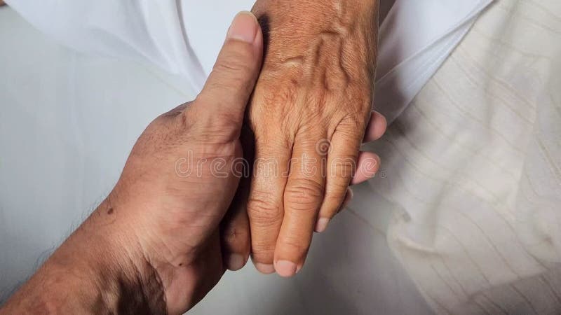 Hands holding and stroking hands senior person, care or support in grief, mental health or anxiety in home, hands close-up, care stock footage