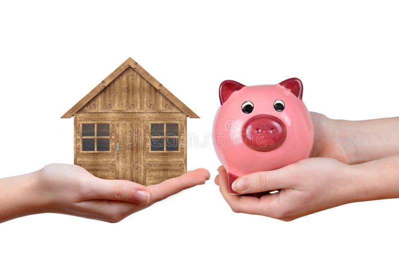 Hands holding wooden house and pink piggy bank