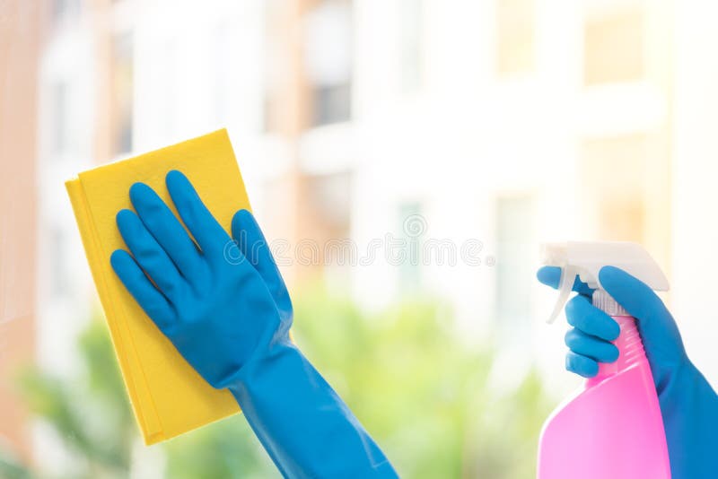 Hands of Housekeeper Cleaning Mirror with Yellow Cloth Stock Image