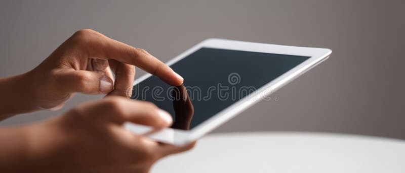 The hands interacting with a modern tablet device on a sleek surface image royalty free stock image.