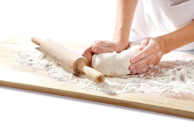 Hands kneading dough on board