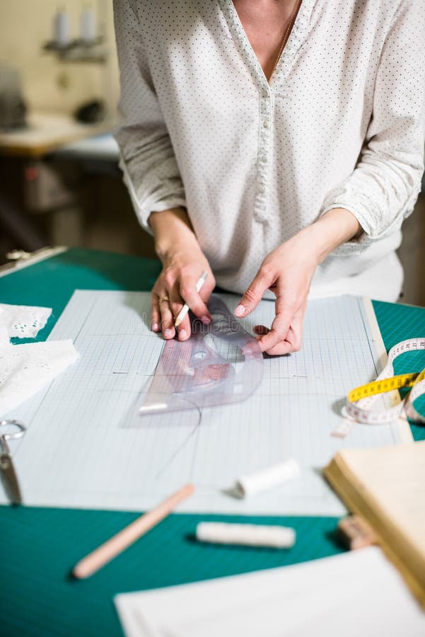 Hands of Lady Tailor Working in Her Studio, Tools and Fabric Samples on