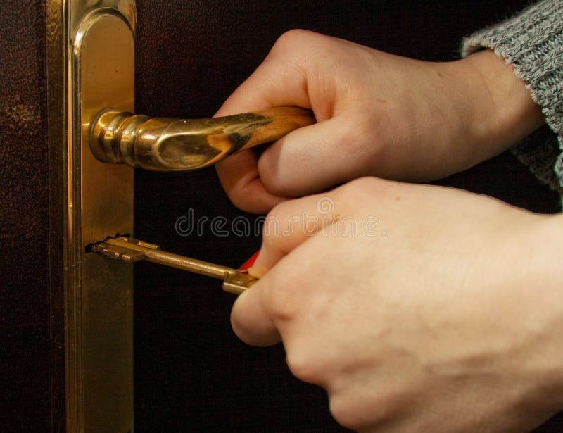 Hands, locking a key an iron door