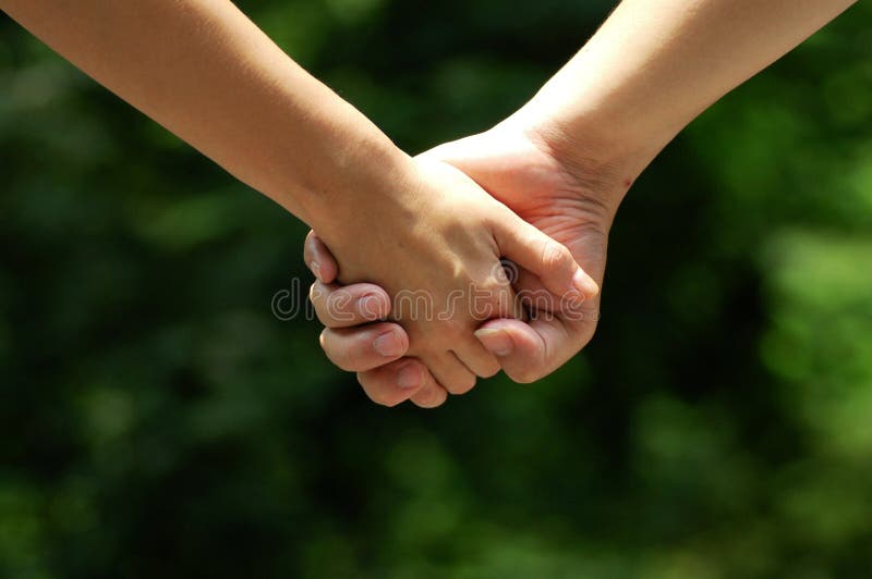 Due innamorati che camminano mano nella mano.