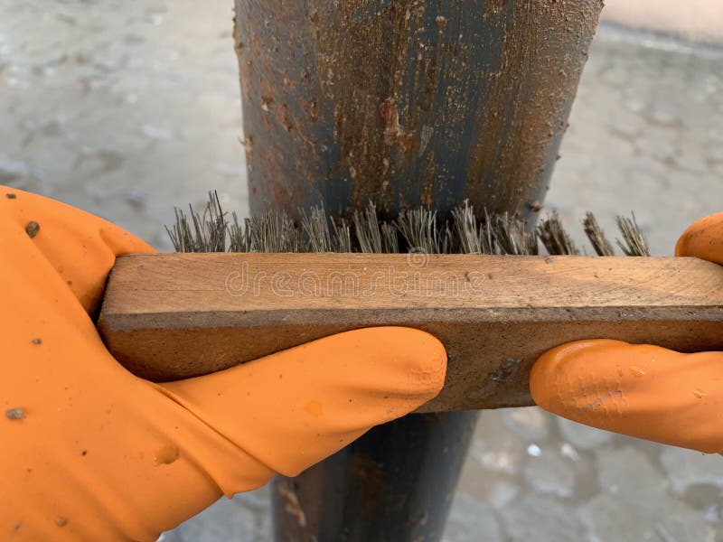 Hands Man with Brush Metal Sanding a Piece of Metal. Closeup. Stock