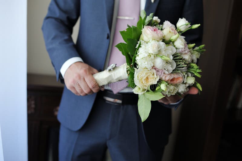 Hands of a man holding a beautiful bouquet of flowers