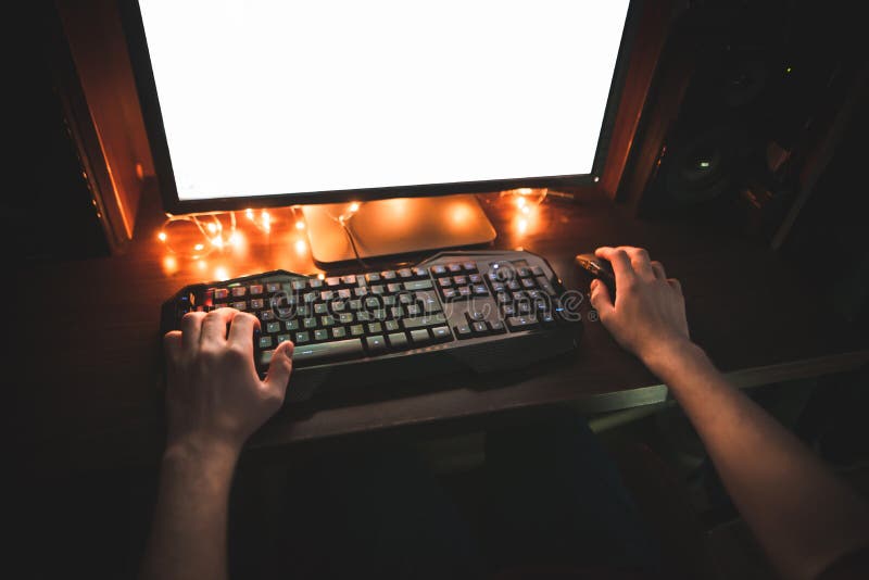 Gamer plays home video games on a computer, keyboard and hands close-up. Gamer concept. Background